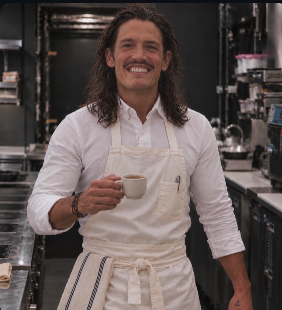 Greg in the kitchen in the morning, holding a cup of coffee